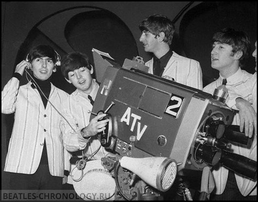 Original caption: "It's a mad fad, Dad!"...These four long-haired lads from Liverpool are "The Beatles," the current sensation among the teenagers of Britain. The Native-son rock n' roll stars are the hottest thing in British show biz since the Lambeth Walk. Exploring the intricacies of the TV camera during a break in rehearsals in Boreham, Hertsfordshire, England, the Beatles are: (left to right) George Harrison; Paul McCartney; Ringo Starr; and John Lennon. Note the "Beatle" straw hat in McCartney's hand. It's part of the rage sweeping the country. Girls and fellows are wearing them as well as wigs to look like their idols. December 21, 1963 Boreham, Hertsfordshire, England